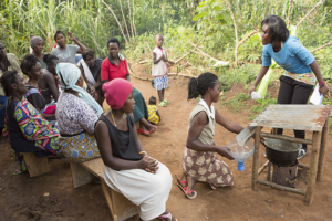 Locals explain their neighbors how their co-designed cooking shelter works, Healthy Cooking Challenge, Uganda